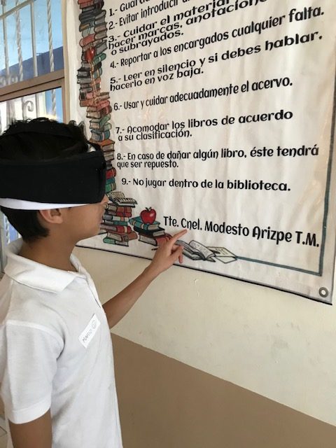 Foto niño leyendo lona con los ojos vendados Foto niño leyendo lona con los ojos vendados